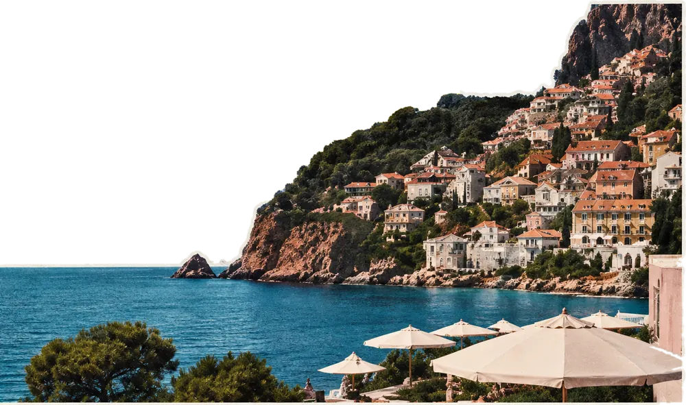 Kivágott kollázs-fotó: mediterrán tengerparti város színes házakkal a sziklás domboldalon, előtérben tenger és napernyős terasz